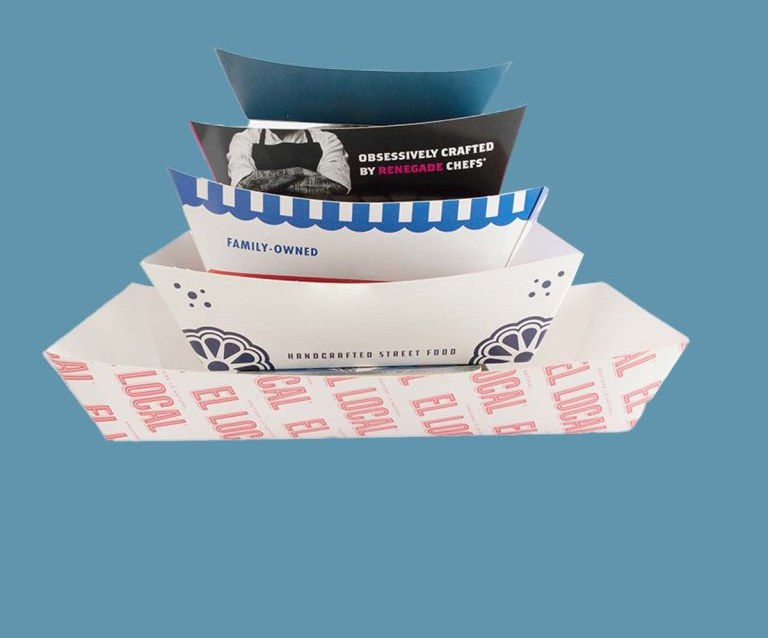 Custom cardboard food trays holding fries and a burger on a counter