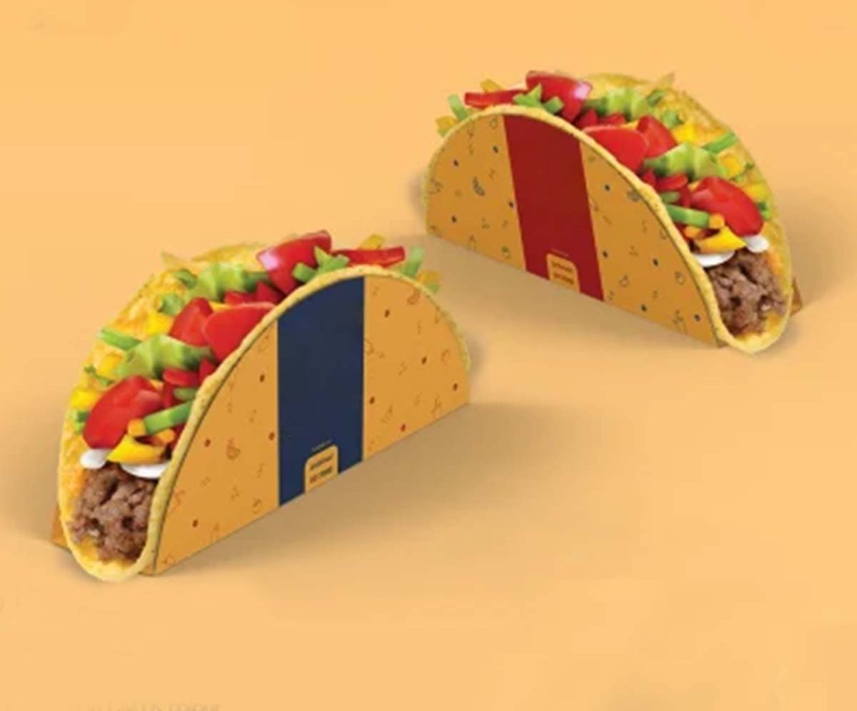 Two filled tacos held in printed board sleeves